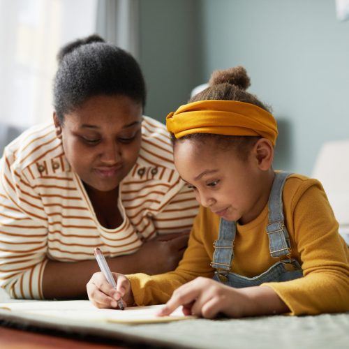 African American Girl Drawing with Mother